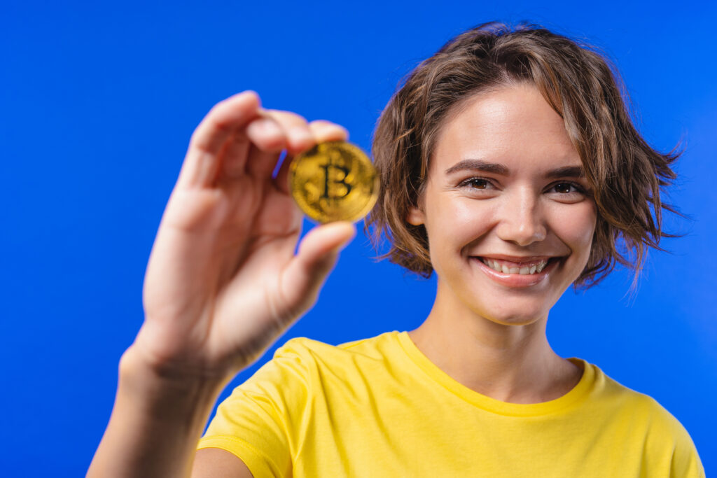 Woman with bitcoin, crypto currency. Golden coin on blue background. Digital exchange, popularity of BTC, symbol of future money, electronics industry, mining concept.